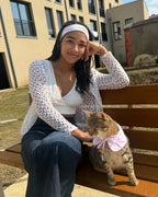 Femme souriante assise sur un banc avec son chat portant un bandana rose pâle, duo matchy fait main Cocoon Pets